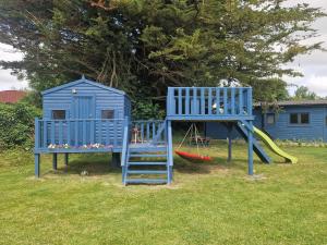 a playground with a blue house and a slide at Pheobes Place in Athlone