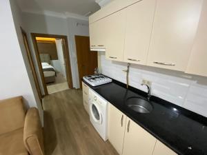 a kitchen with a sink and a washing machine at Parfe Apart in Trabzon +87 photos