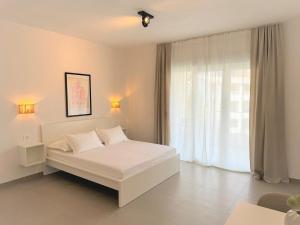 a bedroom with a white bed and a window at Olive Garden in Promajna