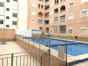 a swimming pool in front of a building at La Loma 72 in Torrevieja