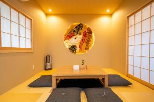 a room with a table and a plate on the wall at 京町家 鯉白-Kyomachiya Rihaku in Kyoto