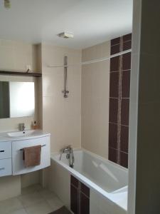 a bathroom with a bath tub and a sink at Maison Centre bourg in Nort-sur-Erdre