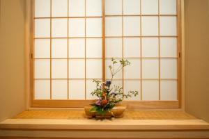 a window with two vases with flowers on a table at 京町家 鯉白-Kyomachiya Rihaku in Kyoto