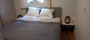 a bed with white sheets and pillows in a room at Serene in Hoenderloo +34 photos