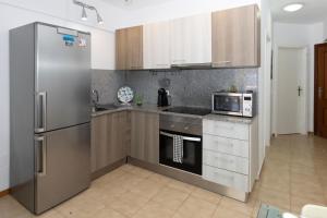 Una cocina con refrigerador de acero inoxidable y microondas. en PARAISO DREAMS, en Playa Paraiso