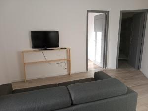 a living room with a couch and a flat screen tv at Appart proche toutes commodités in Souvigny