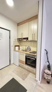 a kitchen with white cabinets and a stove at Apartman Sunce Bjelasnica in Bjelašnica