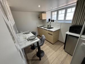a small kitchen with a table and a sink at Tiny room in Langres