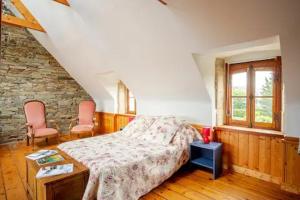 una camera con un letto e due sedie rosa di Ker Wilhelm a Ploubezre