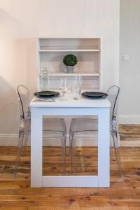 a white table with two chairs and glasses on it at Les deux clefs acte 2 in Mont-de-Marsan