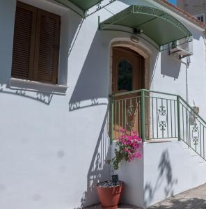 a white house with a balcony with flowers at Τhemis House in Chania Town