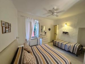 a bedroom with two beds and a ceiling fan at La casa di Andreina in Monterosso al Mare