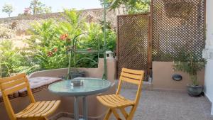 a patio with two chairs and a glass table at Τhemis House in Chania Town