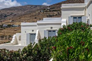 a white house with a hill in the background at Iris house Agios Sostis in Agios Sostis
