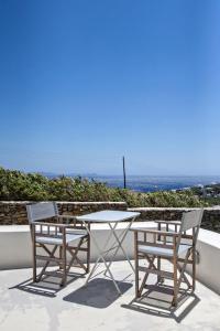 two chairs and a table on a patio with the ocean at Iris house Agios Sostis in Agios Sostis
