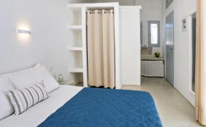 a bedroom with a blue and white bed and a bathroom at Iris house Agios Sostis in Agios Sostis