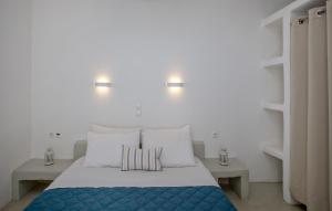a bedroom with a bed with white walls and two tables at Iris house Agios Sostis in Agios Sostis +6 photos