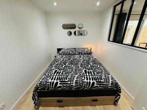 une chambre avec un lit avec une couette noire et blanche dans l'établissement Le Bel Air - Terrasse - WIFI, à Bègles