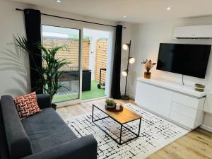 un salon avec un canapé et une télévision dans l'établissement Le Bel Air - Terrasse - WIFI, à Bègles