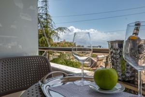 a table with two wine glasses and a green apple at Villa Green Garden in Sarandë