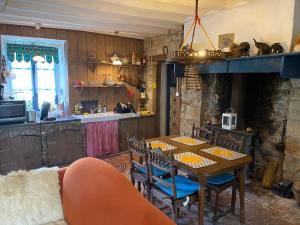 a dining room with a table and a kitchen at Maison L’Atelier in Thollet
