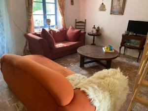 a living room with a couch and a table at Maison L’Atelier in Thollet