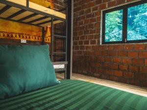 een slaapkamer met een bed met een bakstenen muur bij Og homes in Ha Giang