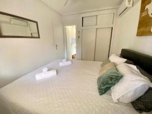 a bedroom with a white bed with pillows on it at La Mata beach apartment Viñamar I, 200m from the beach in La Mata