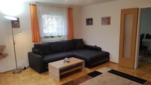 a living room with a black couch and a table at 4 Zimmerwohnung 81m2 Nähe Stuttgart Airport Messe, Esslingen, Stadtbahn U7 in Ostfildern