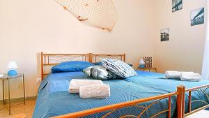 a bedroom with a bed with blue sheets and pillows at La casa di Fra e Pit in Gallico