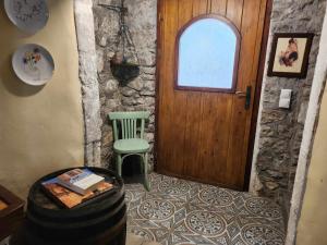 Habitación con puerta de madera y silla verde. en Traditional farmhouse, en Alexandros