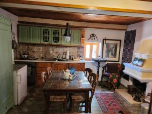 Una cocina con una mesa y sillas en una cocina. en Traditional farmhouse, en Alexandros