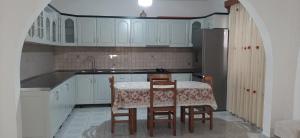 a kitchen with white cabinets and a table and chairs at House 28 in Orikum