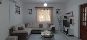 a living room with a couch and a tv at House 28 in Orikum