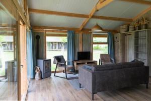 a living room with a couch and a tv at Landrijk De Reesprong boerderij in Haaksbergen