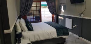 a bedroom with a bed in a room with a window at Happy Haven in Welkom
