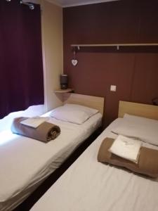 Giường trong phòng chung tại MOBILHOME COSY SPACIEUX 42m2, CLIMATISE, TV & LL, 3 chambres