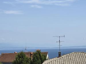 a view of the ocean from the roofs of houses at Apartman Blue in Lovran +2 photos