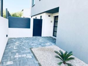 a white house with a black door and a courtyard at Residence Doli Pool in Vrsi
