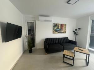 a living room with a black couch and a table at Residence Doli Pool in Vrsi