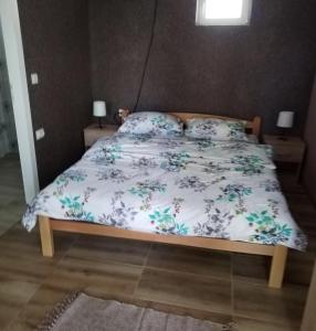 a bedroom with a bed with a floral bedspread at HiT apartmani Pačir2&3 in Pačir +5 photos