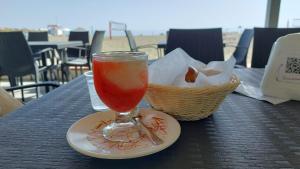 a drink on a plate on a table with a basket at La casa sul mare in Patti