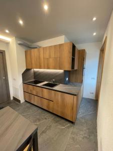a kitchen with wooden cabinets and a sink at Trilocale nel centro storico di Bormio in Bormio