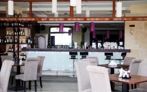 a restaurant with tables and chairs and a bar at Selena Hotel in Balchik