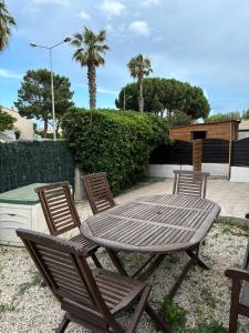 a wooden table and four chairs sitting around a table at Appartement proche de la mer in Sainte-Marie-la-Mer