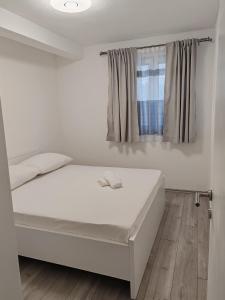 a white bed in a room with a window at Apartman Iva in Neum