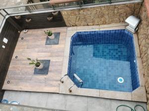 an overhead view of a swimming pool with two plants at Casa Azul na Praia do Verão Vermelho in Cabo Frio +21 photos