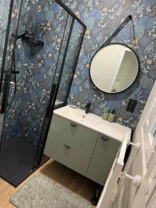 un bagno con lavandino e specchio di Chez Julien à 2 pas de La Défense a Puteaux