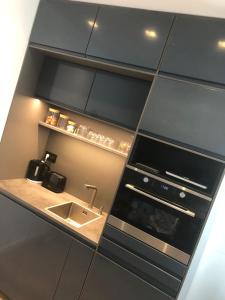 una cucina con armadi neri e lavandino di Chez Julien à 2 pas de La Défense a Puteaux