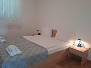 sypialnia z łóżkiem z parą ręczników w obiekcie Apartman zarok w Bašce